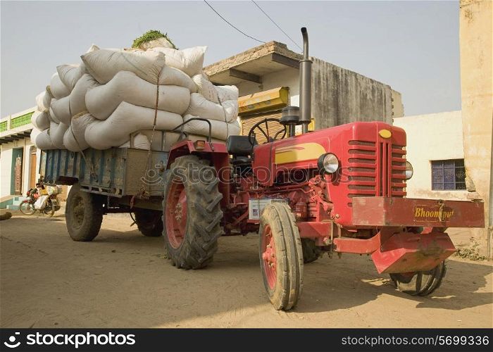 A tractor with a trailer filled with sac