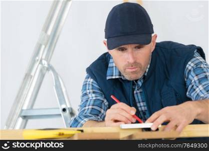 a tradesman is marking wood