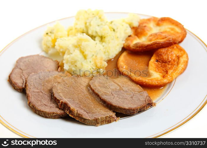 A traditional British meal of roast beef silverside with Yorkshire puddings (popovers) and mashed parsley potatoes.