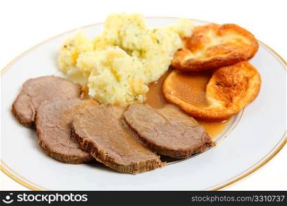 A traditional British meal of roast beef silverside with Yorkshire puddings (popovers) and mashed parsley potatoes.
