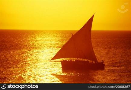 a traditional Dhoni Sailboat at the Indian Ocean in front of the Old Town of Stone Town on the Island of Zanzibar in Tanzania. Tanzania, Zanzibar, Stone Town, October, 2004