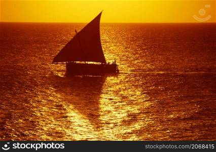 a traditional Dhoni Sailboat at the Indian Ocean in front of the Old Town of Stone Town on the Island of Zanzibar in Tanzania. Tanzania, Zanzibar, Stone Town, October, 2004