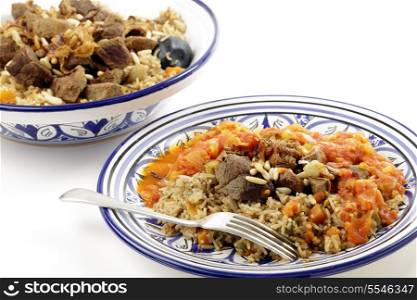 A traditional Saudi Arabian or Gulf Arab meat kabsa meal, of rice, onion, carrots, capsicum, spices, and beef, served with a homemade tomato sauce topping. This originates from Yemen and is known as majbus or machboos in some countries, it is being served on Tunisian dinnerware