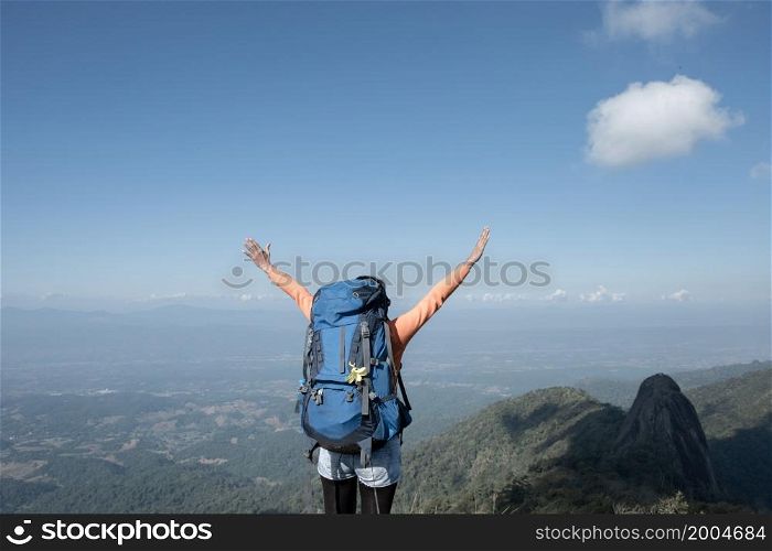 A trekker extends his arms on top of the mountain.