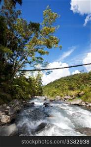 A tropical mountain stream with hanging bridge