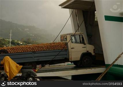 A truck loaded with pineapples being loaded into a barge, Papeete, Tahiti, French Polynesia, South Pacific