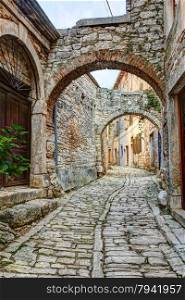 A typical narrow street or alley with stone houses in the hilltop town of Bale or Valle in Istria, Croatia.