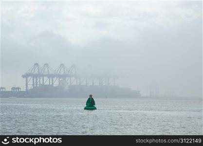 A UK container port shrouded in sea fog - logos removed