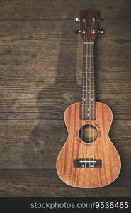 A ukulele musical instrument resting on wooden slats