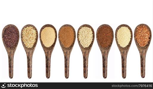 a variety of gluten free grains (from left: black quinoa, buckwheat, amaranth, teff, sorghum, kaniwa, millet, and brown rice) - set of wooden spoons isolated on white