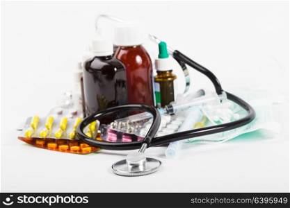 A variety of medicine and stethoscope on white background. A variety of medicine