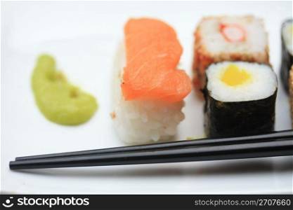 a variety of sushi: Nigirisushi, rice with a raw fish topping and Makisushi, rice wrapped in a thin slice of seaweed, called nori.