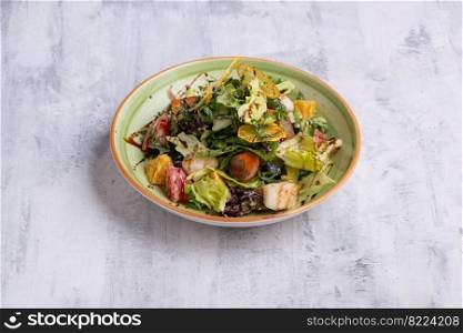 A vegetable salad with fish in a green plate. Vegetable salad with fish in a green plate