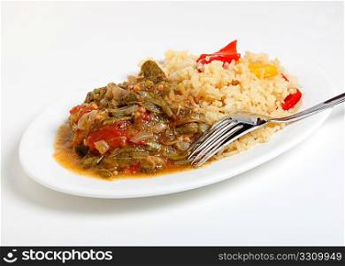 A vegetarian meal of okra stewed with onion and tomato, served with spicy cajun rice