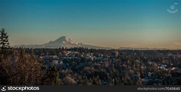 A veiw of Mount Rainier on a clear winter day with homes in the forefround. Shot taken from Burien, Washington.