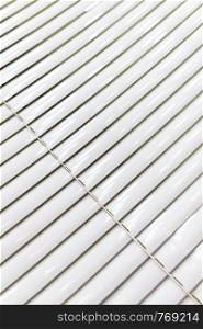 A venetian blind in white tone. There is landscape in the background