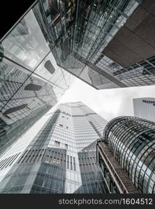 A vertical low angle shot of a modern business building scenery touching the sky. Vertical low angle shot of a modern business building scenery touching the sky