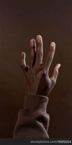 A vertical photo of a black hand