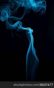 A vertical shot of blue tobacco smoke on a black background. Vertical shot of blue tobacco smoke on a black background