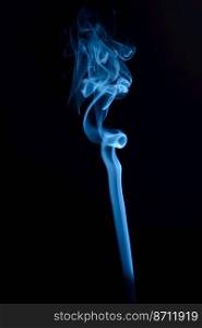 A vertical shot of blue tobacco smoke on a black background. Vertical shot of blue tobacco smoke on a black background