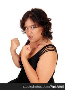 A very angry mixed raced woman in a black dress is ready for a fist fightisolated for white background.