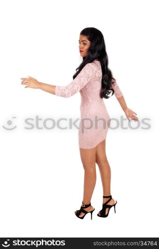 A very beautiful young woman walking in a beige tight dress andlong black hair isolated for white background.