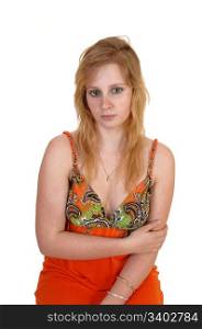 A very distressed and lonely blond teenager girl in a colorful orange dresssitting in the studio and looking sad around, for white background.