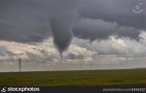 A very large funnel cloud sits feet off the ground, threatening a tornado is imminent