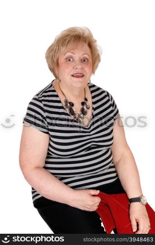 A very surprised looking senior woman sitting on a chair with big eye&rsquo;s,isolated for white background.