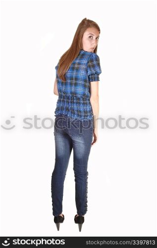 A very tall teenager in jeans and a chickened blue blouse, standing fromthe back and looking over her shoulder, for white background.