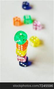 A vibrant colorful macro with depth of field about glass gambling dice, isolated and stacked ones, on white background.