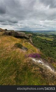 A view from the edge of a hill with Heather on a rock in the Peak District, Derbyshire