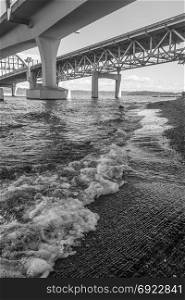 A view from under the I-90 bridge in Seattle, Washington. Black and white image.
