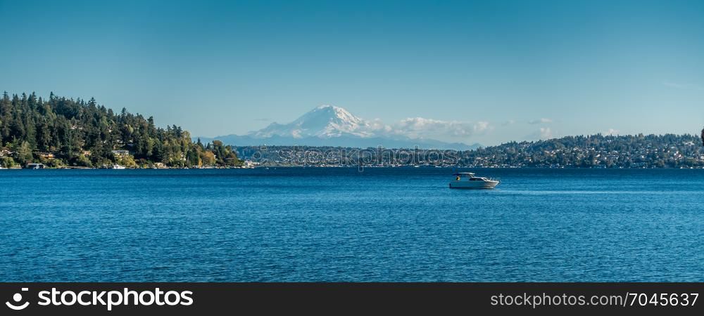 A view Mount Rainier and a boat on Laie Washington. Photo taken at Seward Park near Seattle.