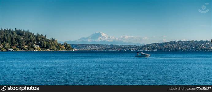 A view Mount Rainier and a boat on Laie Washington. Photo taken at Seward Park near Seattle.