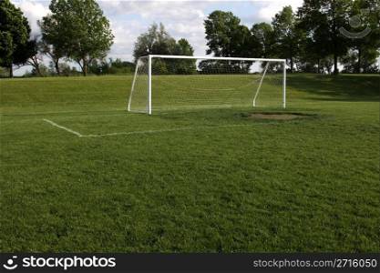 A view of a net on a vacant soccer pitch.. Empty Soccer Goal