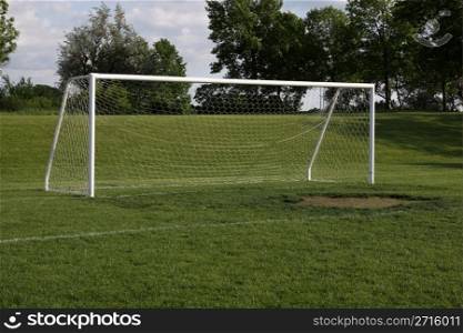 A view of a net on a vacant soccer pitch.. Empty Soccer Net