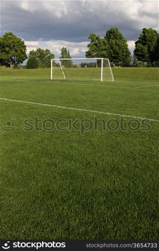 A view of a net on a vacant soccer pitch.. Unoccupied Soccer Field