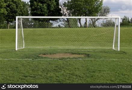 A view of a net on a vacant soccer pitch.. Wide Open Soccer Net