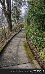 A view of a sidewalk leading the water at Lincon Park in West Seattle, Washington.