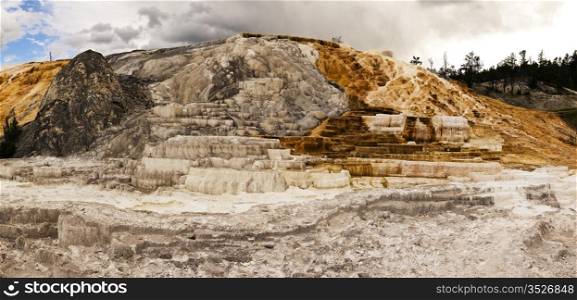 A view of one of the main features at Mammoth Hot Springs. The stone (travertine marble) is formed from the minerals in the water from the hot springs that have built up over years into a structure appearing like layers of a wedding cake.