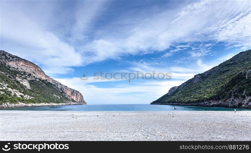 A view of the beautiful Greek sand beach with cliffs. Holidays in warm countries concept.. Beautiful Greek sand beach with cliffs