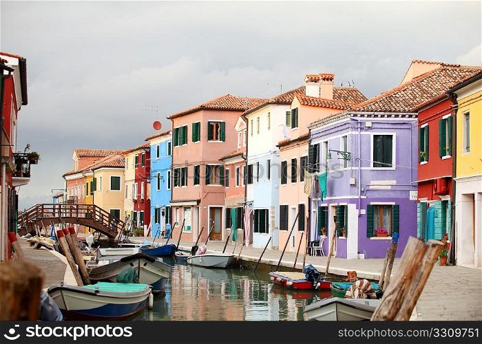 A view of the brightly painted island of Burano, Venice, under a stormy sky