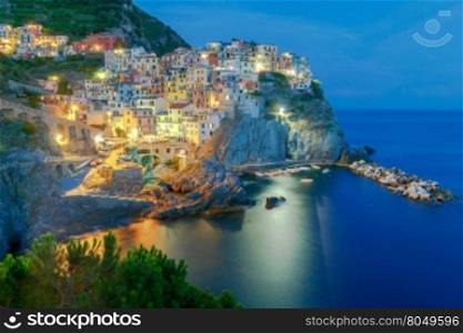 A view of the colorful traditional houses on the rock on sunset. The coast of Liguria. Manarola, Cinque Terre.