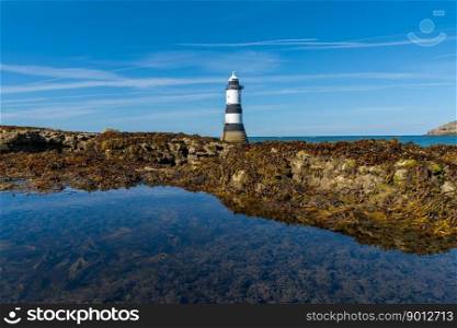 A view of the Penmon Lighthouse in North Wales with a tidal pool in the foreground