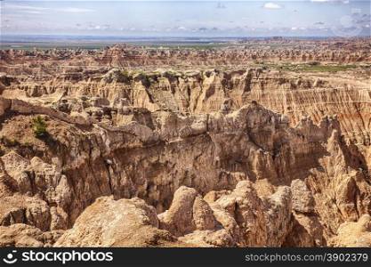 A view of the Pinnacles portion of Badlands National Park in South Dakota showcases the erosion within the hills with just a hing of the grasslands in the distance.