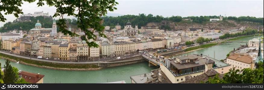 a view right from the hill into the city center of Salzburg - Austria..Panoramic image of Salzburg. Mozart&rsquo;s old town with Alps in the far background.