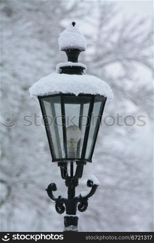 A vintage lantern covered in snow