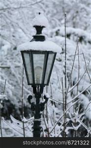 A vintage lantern covered in snow
