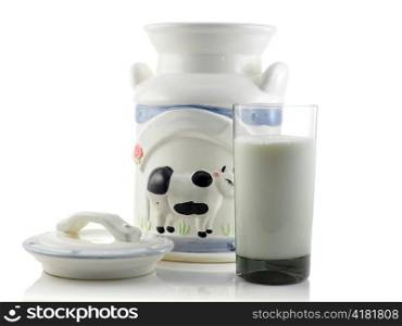 a vintage milk jug and glass of milk on white background